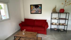 a living room with a red couch and a table at Maison indépendante dans Mas Provençal in Avignon