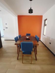 a dining room with a wooden table and blue chairs at Apartamento #12 Portal de Occidente in Quetzaltenango