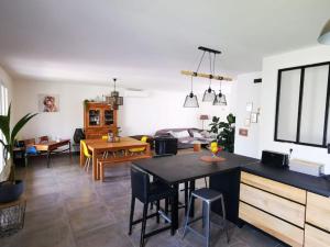 a kitchen and living room with a table and chairs at Agréable Villa proche Pont du Gard in Bezouce