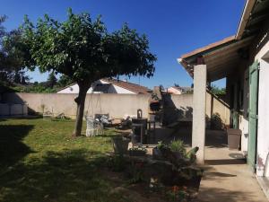 a yard with a tree and a house at Agréable Villa proche Pont du Gard in Bezouce