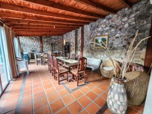 a dining room with a table and chairs and a stone wall at Mamá Quilla in La Rioja