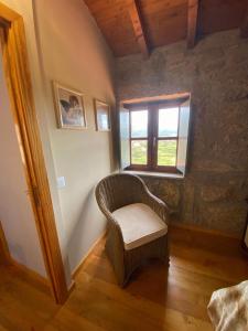 una sedia in vimini in una stanza con finestra di Casa da iapa a Soajo