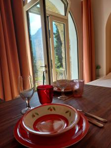 a wooden table with a plate and glasses on it at Villa Annamaria - b&b in Ballabio