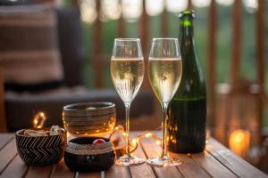 two glasses of champagne and a bottle on a table at Les Lodges du Quercy in Saint-Cernin