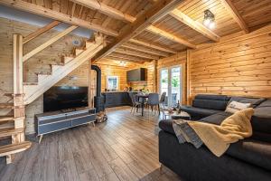 a living room with a couch and a staircase at Mazurskie Wzgórze - domki całoroczne HOME APART in Ostróda