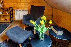 a room with a chair and a vase of flowers on a table at Kresy in Wajków