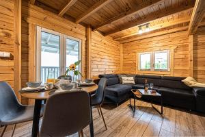 a living room with a couch and a table at Mazurskie Wzgórze - domki całoroczne HOME APART in Ostróda