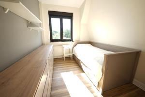 ein kleines Schlafzimmer mit einem Bett und einem Fenster in der Unterkunft Ferienhaus in Brandenburg an der Havel in Brandenburg an der Havel