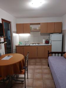 a small kitchen with a table and a bed at Sandra Apartmani 3 in Zaostrog +13 photos