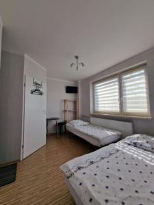 a bedroom with two beds and a window at Noclegi nad Wodą in Brzeźnica
