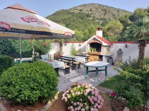 an outdoor patio with a table and an umbrella at Sandra Apartmani 3 in Zaostrog