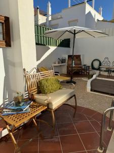 a patio with a bench and an umbrella at Villa 46 Hostel in Lagos