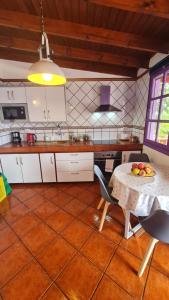 a kitchen with a table with a bowl of fruit on it at Los Cerrajones: spectacular views from the cliff in Agulo