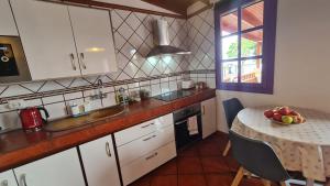a kitchen with a table with a bowl of fruit on it at Los Cerrajones: spectacular views from the cliff in Agulo