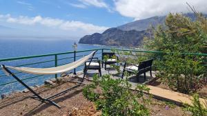 a hammock and chairs on a balcony overlooking the ocean at Los Cerrajones: spectacular views from the cliff in Agulo