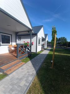 een achtertuin met een houten terras en een huis bij Bałtyk i Las in Rusinowo
