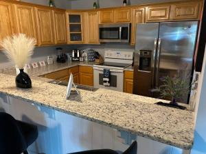 a kitchen with a granite counter top and stainless steel refrigerator at 3 bed 3 bath home Dtown Gainesville in Gainesville +34 photos