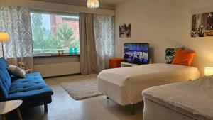 a bedroom with a bed and a tv and a couch at Himoksesta 30km, Halli, asunto 2-3hlöä,B12 in Jämsä