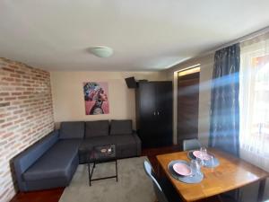 a living room with a couch and a table at Summer Apartments in Tiszakécske