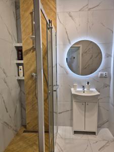 une salle de bain avec un lavabo et un miroir dans l'établissement Apartament Sportowa przy SUNTAGO DEEPSPOT Mszczonów, à Mszczonów