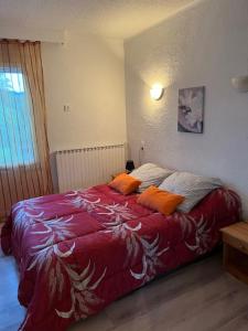 a bedroom with a bed with orange pillows on it at Attrap'R&ecirc;ves in Aspres-sur-Bu&euml;ch