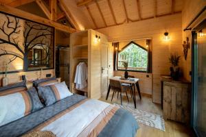 a bedroom with a bed and a desk and a window at Les Lodges du Quercy in Saint-Cernin