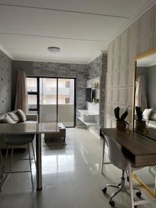 a living room with a dining table and a couch at Classy 2 bedroom in Halfway Gardens in Midrand