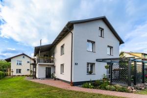 a white house with a black roof at Pokoje Gościnne Lipowa in Sztutowo