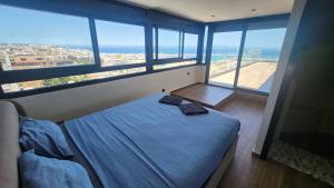 a bedroom with a bed in a room with windows at Magnifique penthouse 160m2 terrasse 90m2 vue mer in Tangier +36 photos