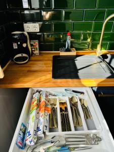 沙博伊茨Familientraum an der wunderschönen Ostsee in Scharbeutz - Strandnah, kostenloses Parken & Terasse!W2的水槽旁边的柜台上放着一盘餐具