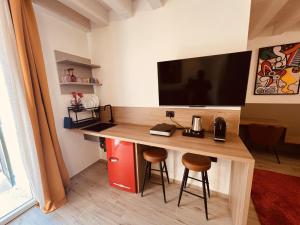 a room with a desk with a television on a wall at CINQUE TERRE Hub Suite ART in La Spezia