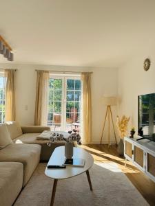 沙博伊茨Familientraum an der wunderschönen Ostsee in Scharbeutz - Strandnah, kostenloses Parken & Terasse!W2的客厅里有一张沙发和一张桌子。