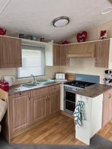 a kitchen with wooden cabinets and a stove top oven at 613 Promenade, Ingoldmells in Ingoldmells