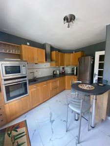 a kitchen with wooden cabinets and a table with a pizza on it at Villa Les Tourelles in Flers +2 photos