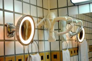 a bathroom with a mirror on a wall with towels at Hotel Cidade in Passos