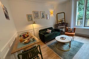 a living room with a green couch and a table at L'écrin à la Parisienne in Clichy