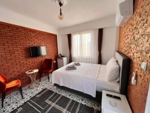 a bedroom with a bed and a brick wall at Siesta butik otel 17 in Ayvacık