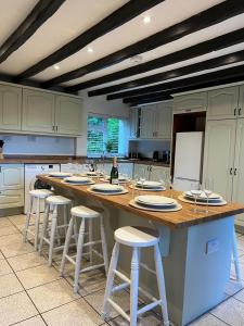 a large kitchen with a large island with bar stools at Plasbach Cottage in Llandeilo