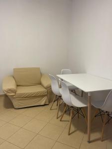 a living room with a couch and a table and chairs at Nikolla's apartment in Himare