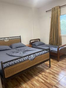 two twin beds in a room with a window at Nikolla's apartment in Himare
