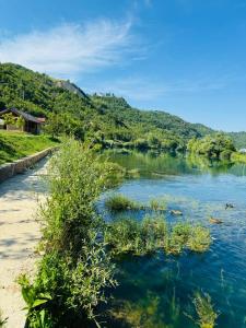 a view of a river with mountains in the background at Dolce vita cottage - waterfront in Bihać