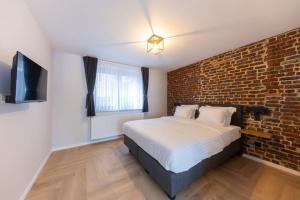 a bedroom with a bed and a brick wall at Midi Stay Brussels in Brussels