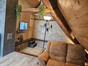 a living room with a couch and a tv at Les Hauteurs de Ranspach in Ranspach