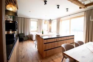 a hotel room with a kitchen and a bedroom at Oberkrammern Premium Appartements in Hollersbach im Pinzgau