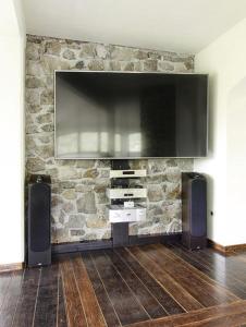 a living room with a fireplace with a flat screen tv at Villa Noiram - Your dream Getaway in Nature in Senožeče