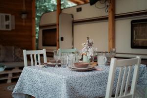 a table with a white table cloth with plates and glasses at Каравана GYPSY in Chernomorets +21 photos