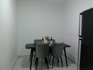a dining room table with three chairs and two bottles of wine at 16 Des Septiembre in Cedro