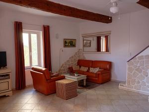 a living room with a couch and a fireplace at La Maison des Vendangeurs à Puisserguier in Puisserguier