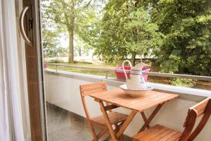 a table and chairs on a balcony with a window at Chez Fiatope in Châtillon
