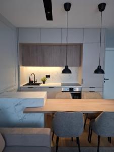 Una cocina con una mesa y sillas de madera. en Sparkle Home, en Banja Luka